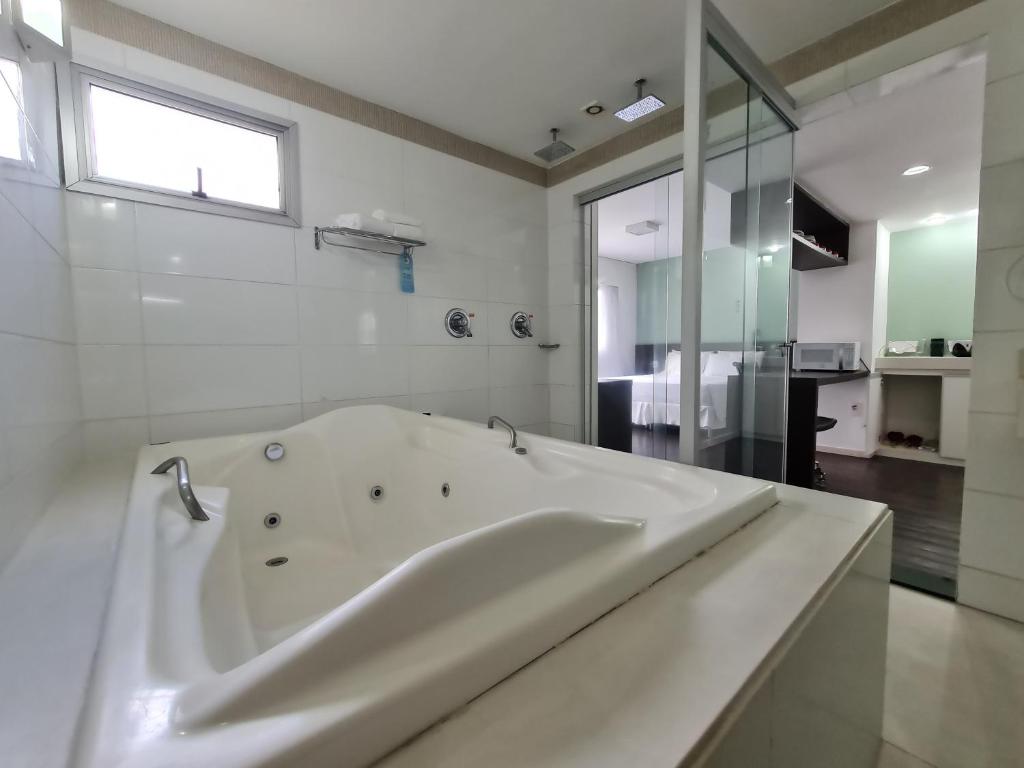 贝洛奥里藏特Wafeh Flats em San Diego Pampulha的白色的浴室设有浴缸和窗户。