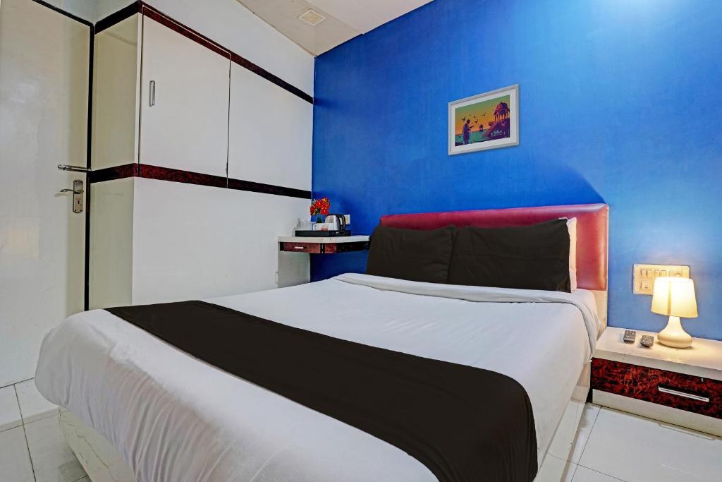孟买OYO Hotel Blue Sea Near Chhatrapati Shivaji International Airport的一间卧室设有一张蓝色墙壁的大床