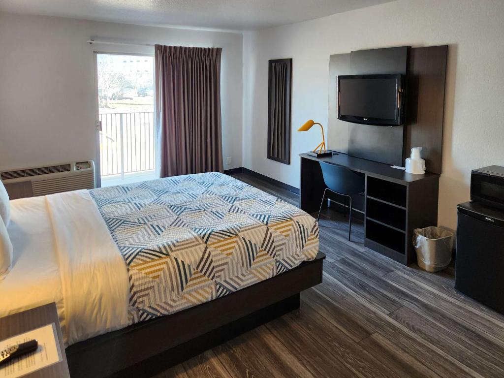 林垦Motel 6-Lincoln, NE - Airport的酒店客房配有一张床、一张书桌和一台电视。
