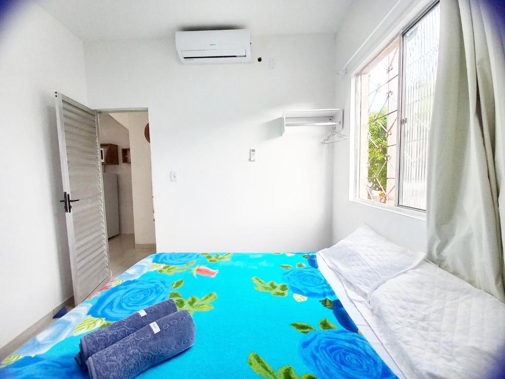 萨尔瓦多Mar.6: spacious 1 room, 2 AC, near Airport and Stella Maris beach的一间卧室配有一张带蓝色毯子的床