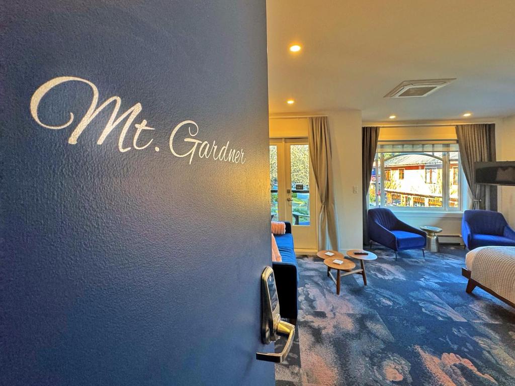 宝云岛鲍恩工匠套房酒店 的客厅配有蓝色椅子和墙上的标志