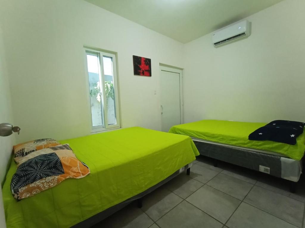蒙特里科CASA PARLAMAR的配有绿床单的客房内的两张床