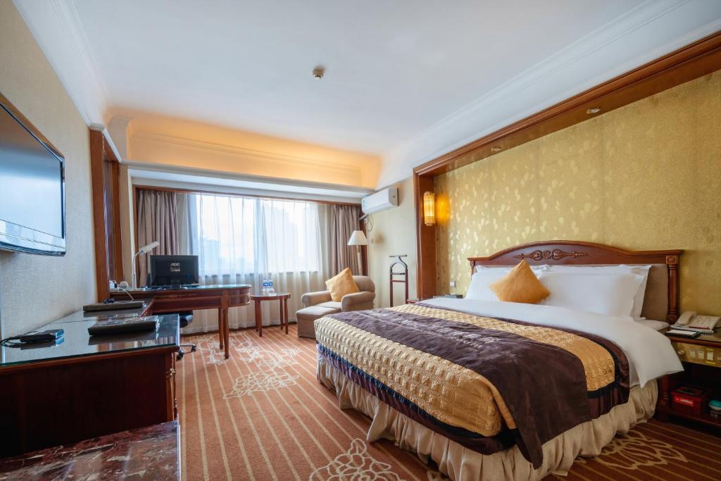 福州福建阳光假日大酒店的配有一张床和一张书桌的酒店客房