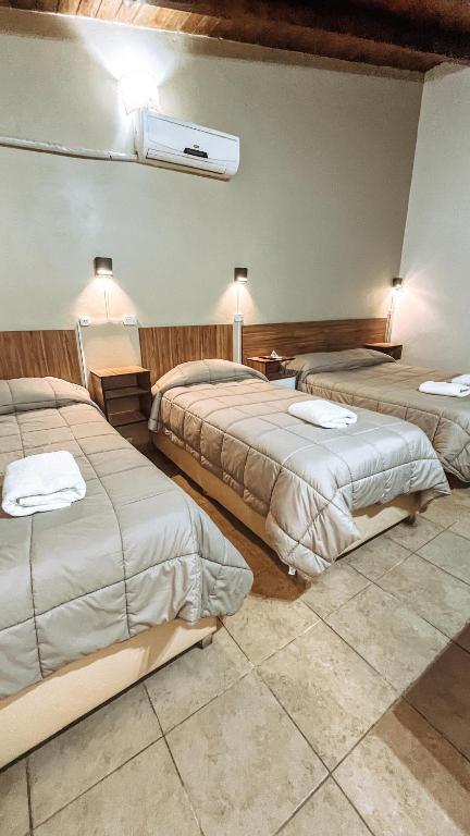 图努扬Hospedaje Los Ilustres的一间酒店客房,房间内设有三张床