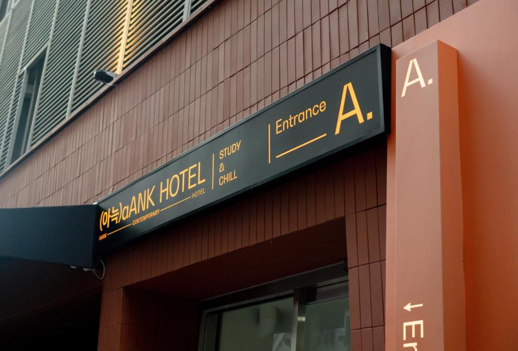 首尔Aank Hotel Sinchon的建筑物一侧的标志