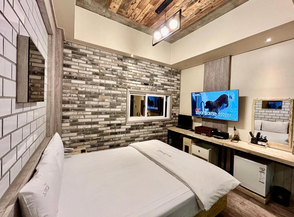 大邱2SOME Motel的一间卧室配有一张床和一台平面电视