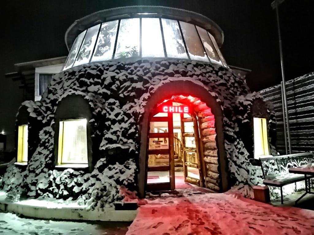 普孔Hotel Catripulli的雪中带红门的姜饼建筑