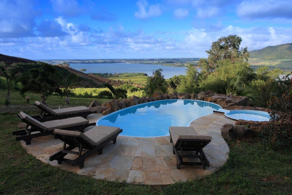 马埃堡毛里求斯牧场旅馆的一个带长椅的游泳池,享有湖景