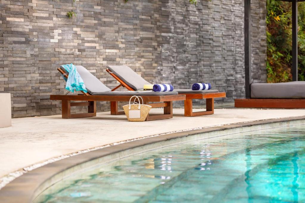 维拉港陶乐苑精品公寓的游泳池旁的带桌椅的游泳池