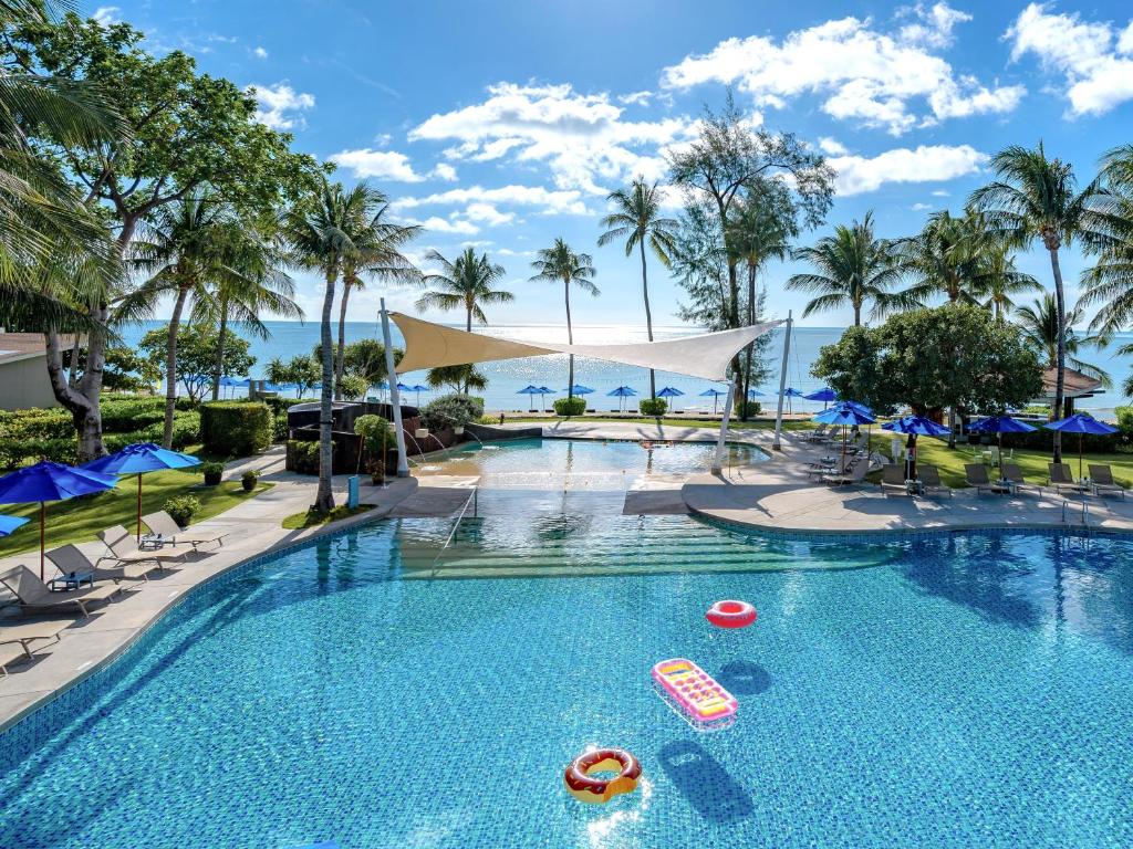 查汶苏梅岛遨舍查汶度假酒店的度假村的游泳池配有椅子和遮阳伞