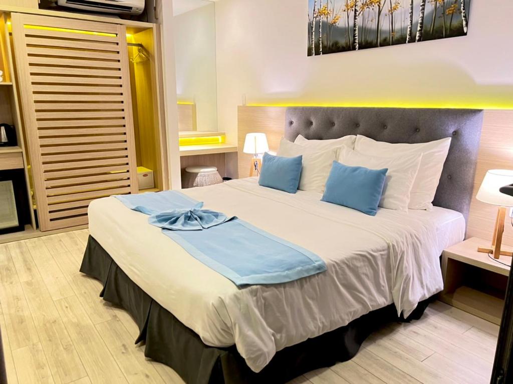隆海Lovely Lady Villa Oceanami Resort, Vung Tau的一间卧室配有一张带蓝色枕头的大床
