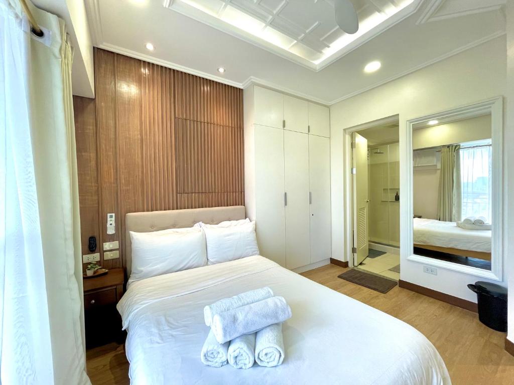 马尼拉mushROOM Condotel at Infina Towers, Quezon City的卧室配有白色床和毛巾