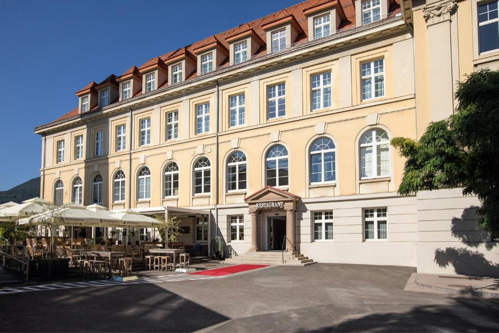 卡普芬贝格Hotel Böhlerstern的一座大建筑前面设有桌椅