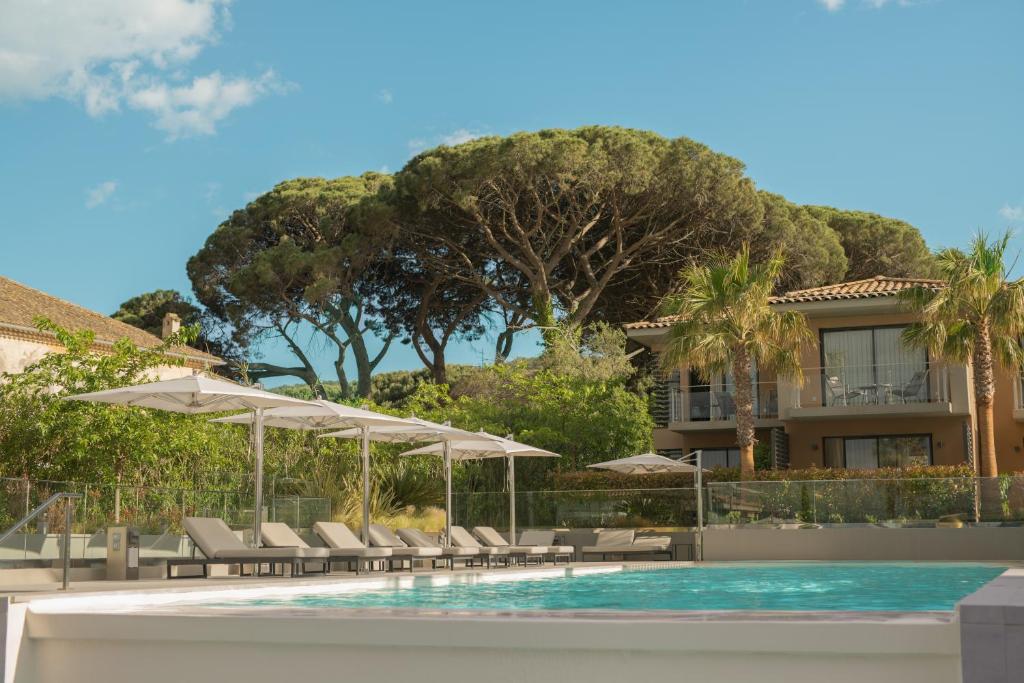 圣特罗佩Kube Saint-Tropez的一个带椅子和遮阳伞的度假游泳池