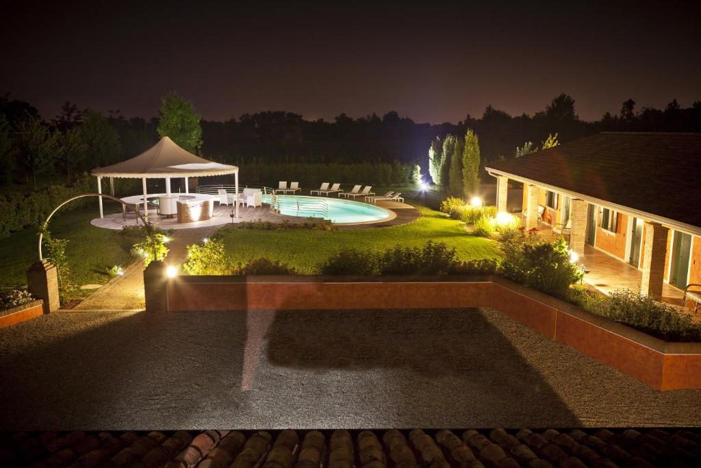 卡多格尼爱卡松尼农场酒店的后院,在晚上设有游泳池和凉亭