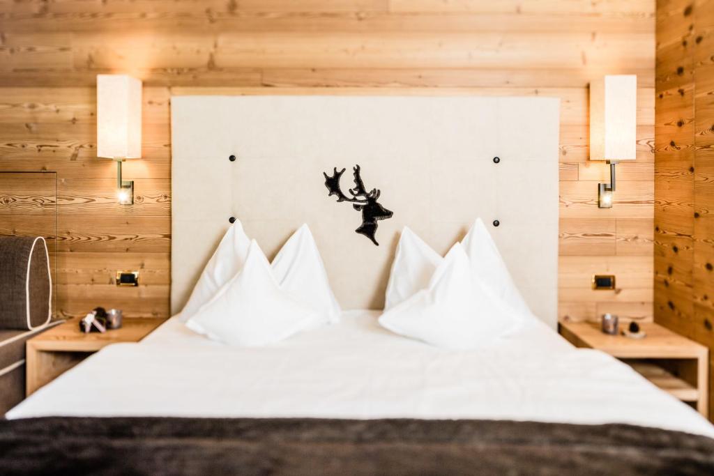 塞尔瓦迪加尔代纳山谷朵夫山魅力酒店的一间卧室配有带白色枕头的床