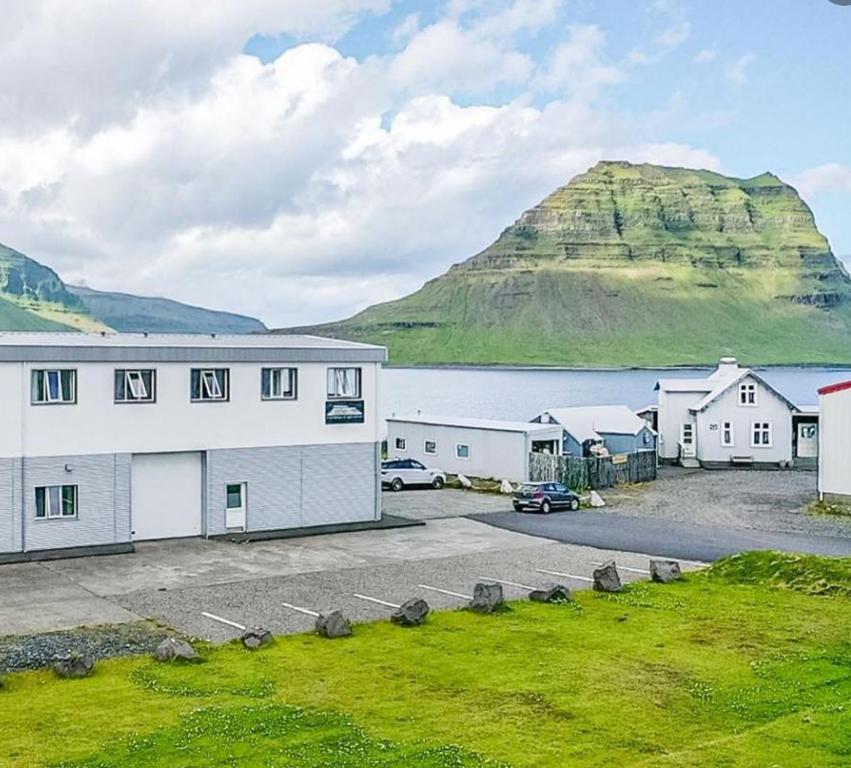 格仑达积图Stöð Guesthouse and apartments的一座白色的大建筑,背景是一座山