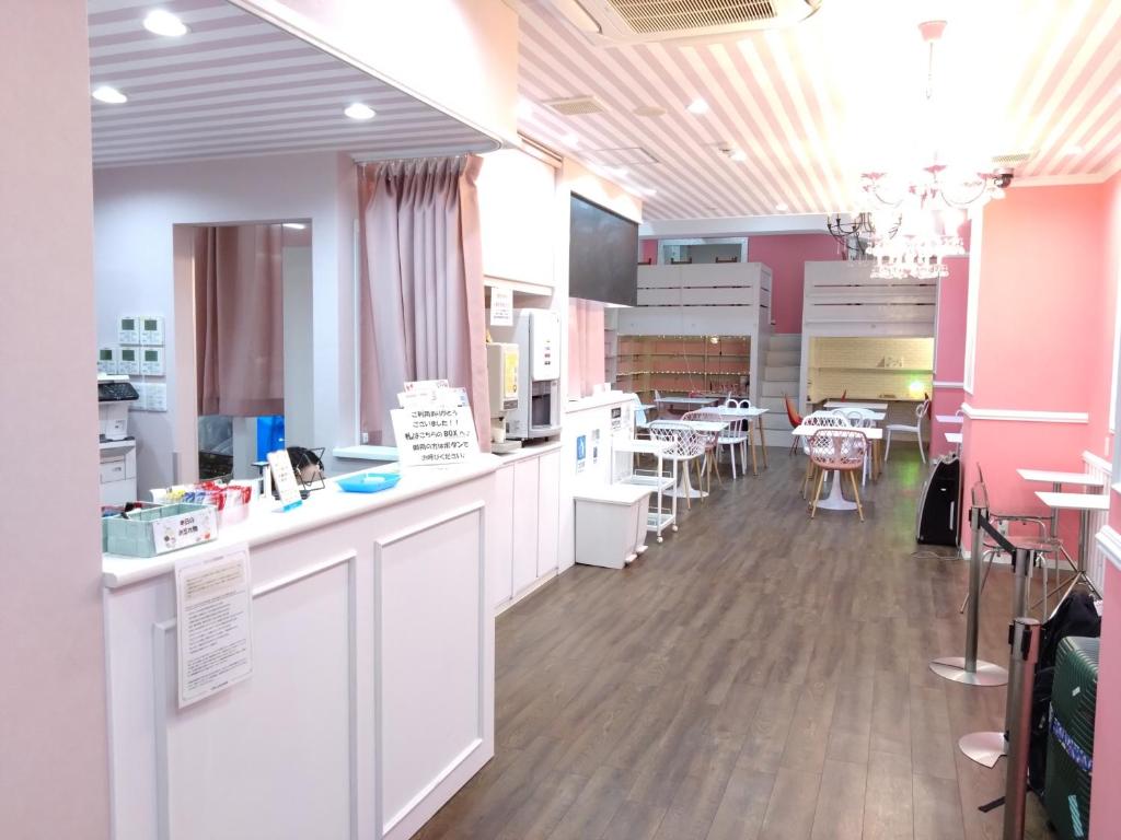 大阪Cafe&Hostel きみといちご的一间带白色柜台的厨房和一间带桌子的用餐室