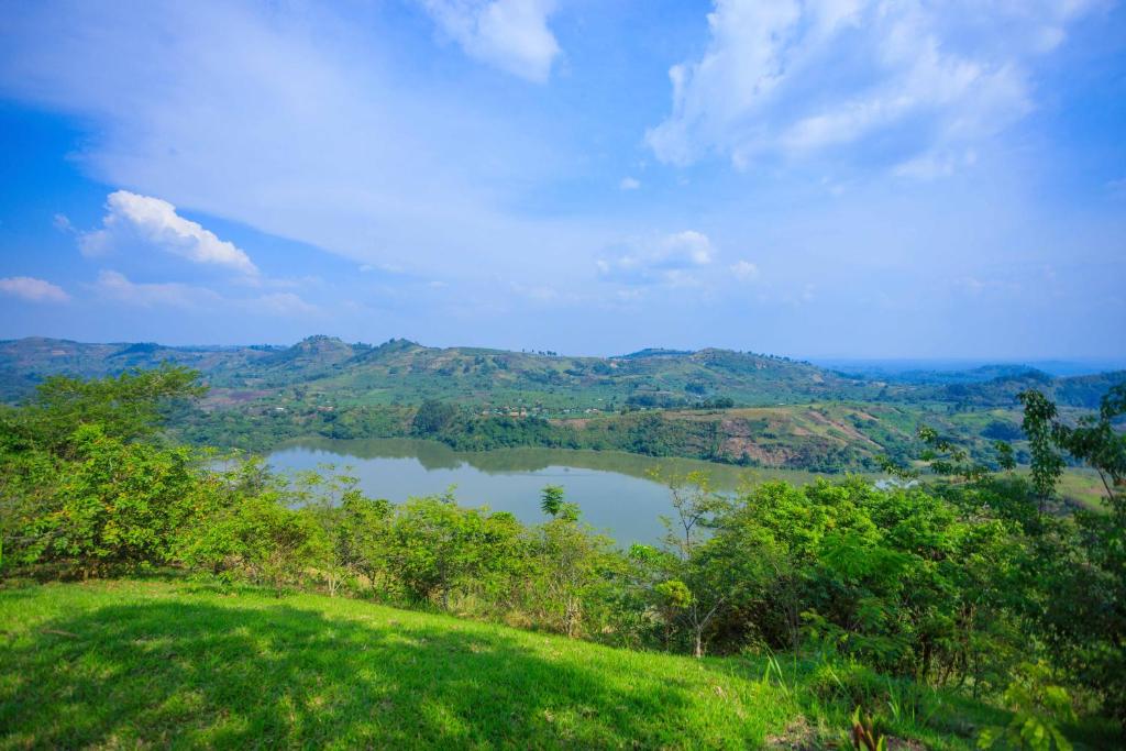 Kasendalake mwamba lodge的从草地山丘上可欣赏到湖泊景色