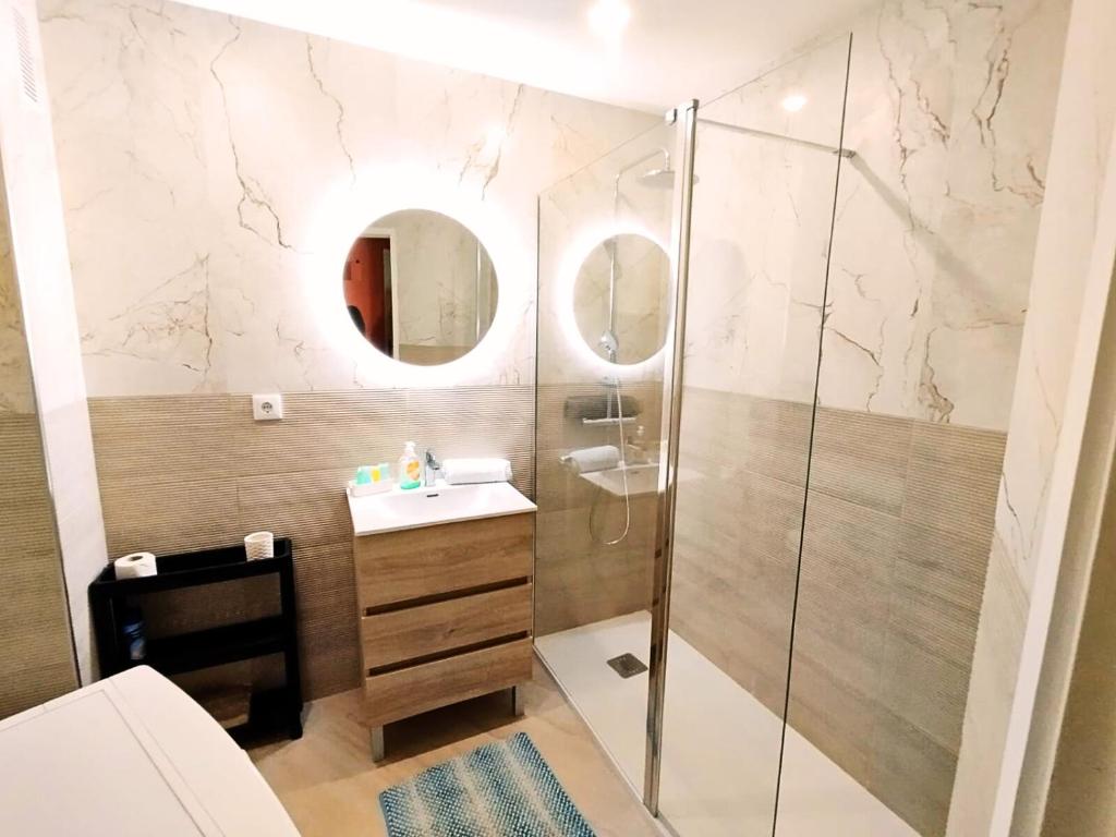 波尔蒂芒Appartement Praia da Rocha的带淋浴、盥洗盆和镜子的浴室