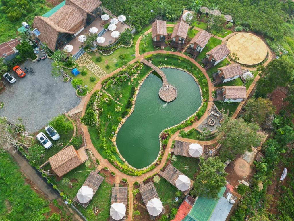 保禄The Homilá Bảo Lộc - Hill View Bungalow & Glamping的享有公园顶部和池塘的景色