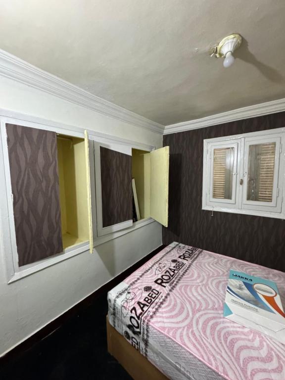 曼苏拉شقه صغيره فندقيه في موقع مميز جديده وفرش وموبيليا جديده的一间卧室设有一张床和两个窗户。