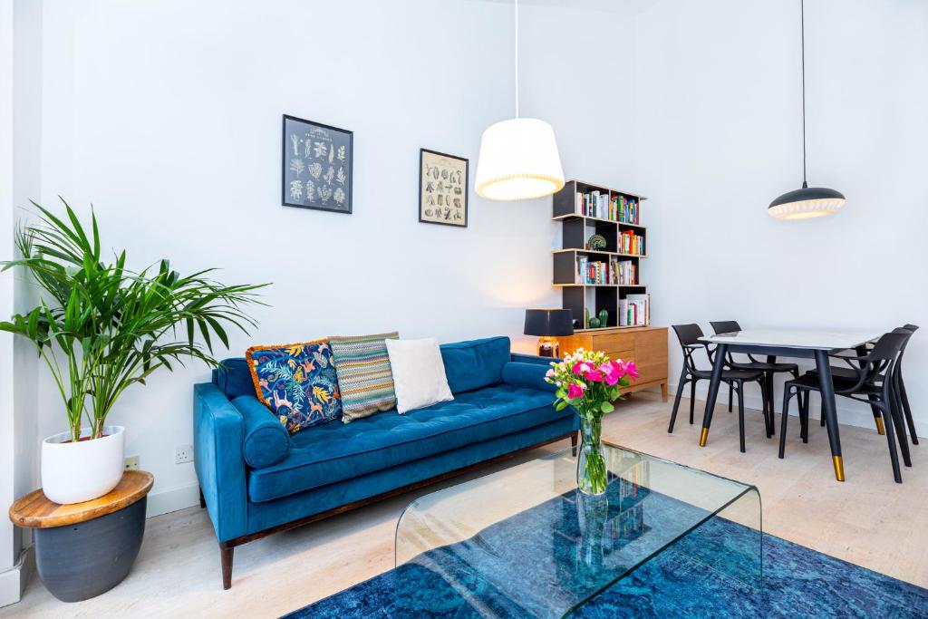伦敦Stylish 1BR apt, 7min Archway Tube & Holloway Rd的客厅配有蓝色的沙发和桌子