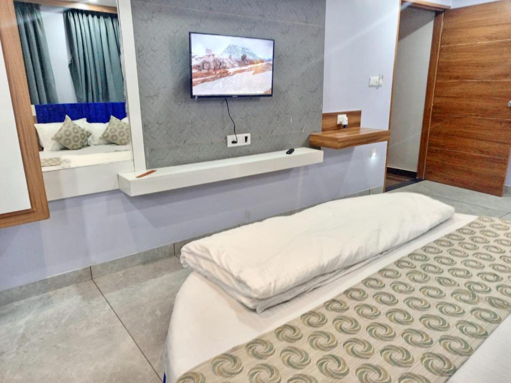 NarodaHotel Red Blue,Ahmedabad的客房设有两张床和一台墙上的电视。