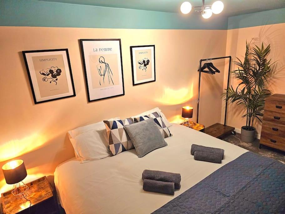 谢菲尔德Homebird Property - Waltz House的卧室配有一张大床,墙上挂有图片