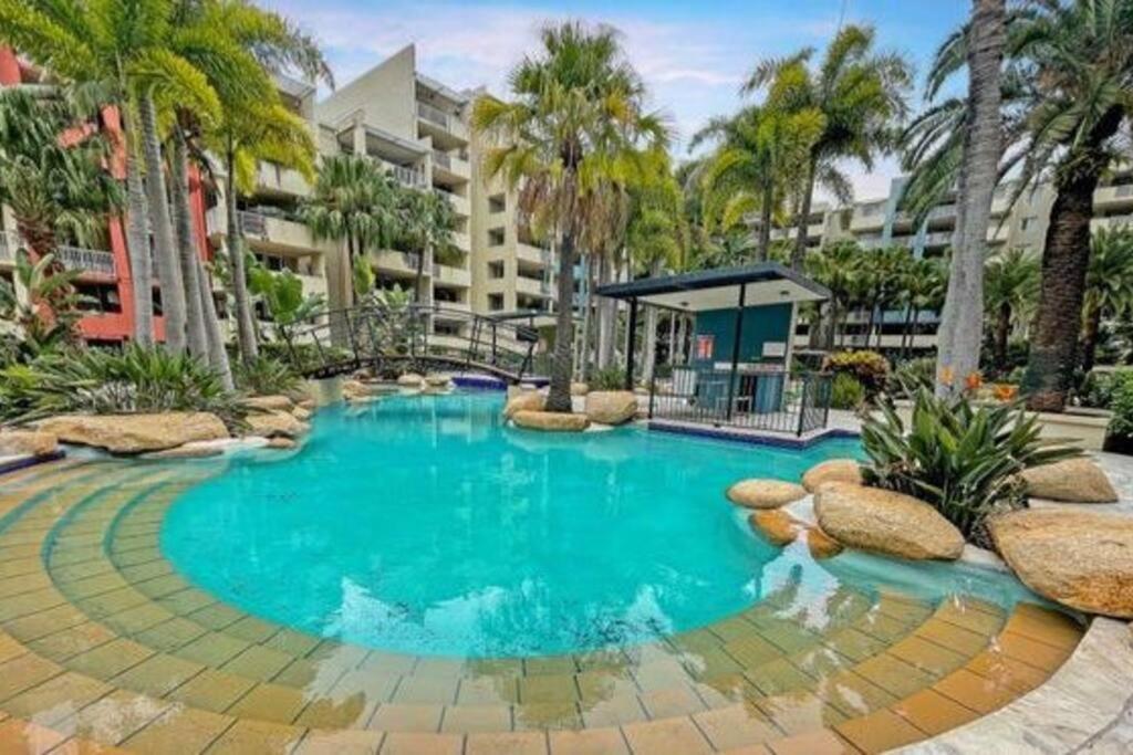 布里斯班Large studio balcony, spa & pool的棕榈树度假村内的游泳池
