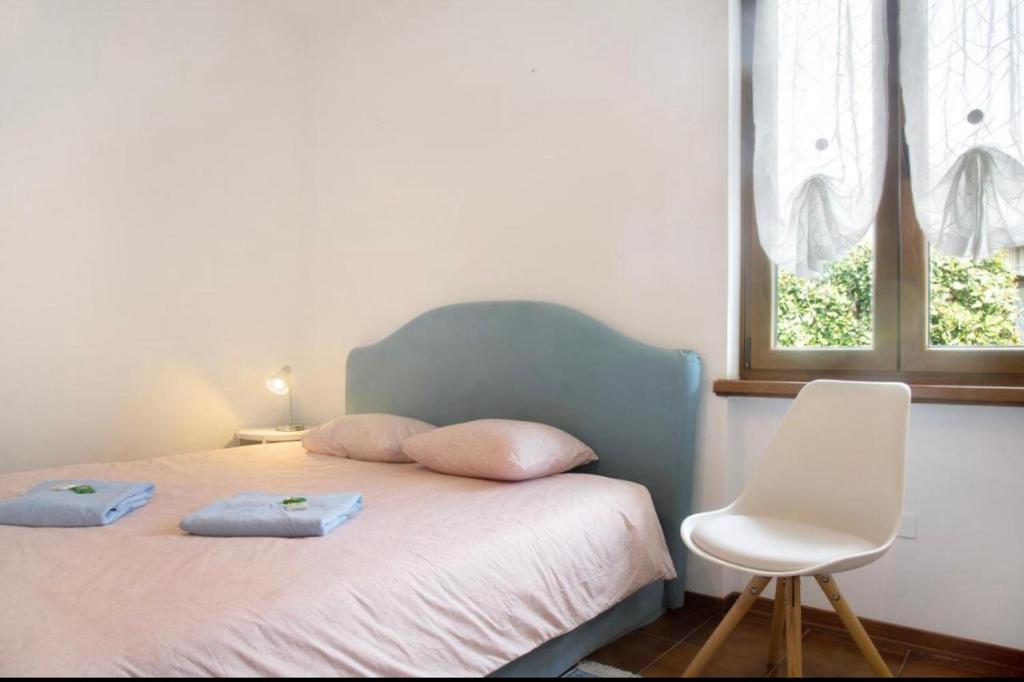 下麦克加诺Terrassen Wohnung Bacio del Sole的一间卧室配有带2个枕头和椅子的床