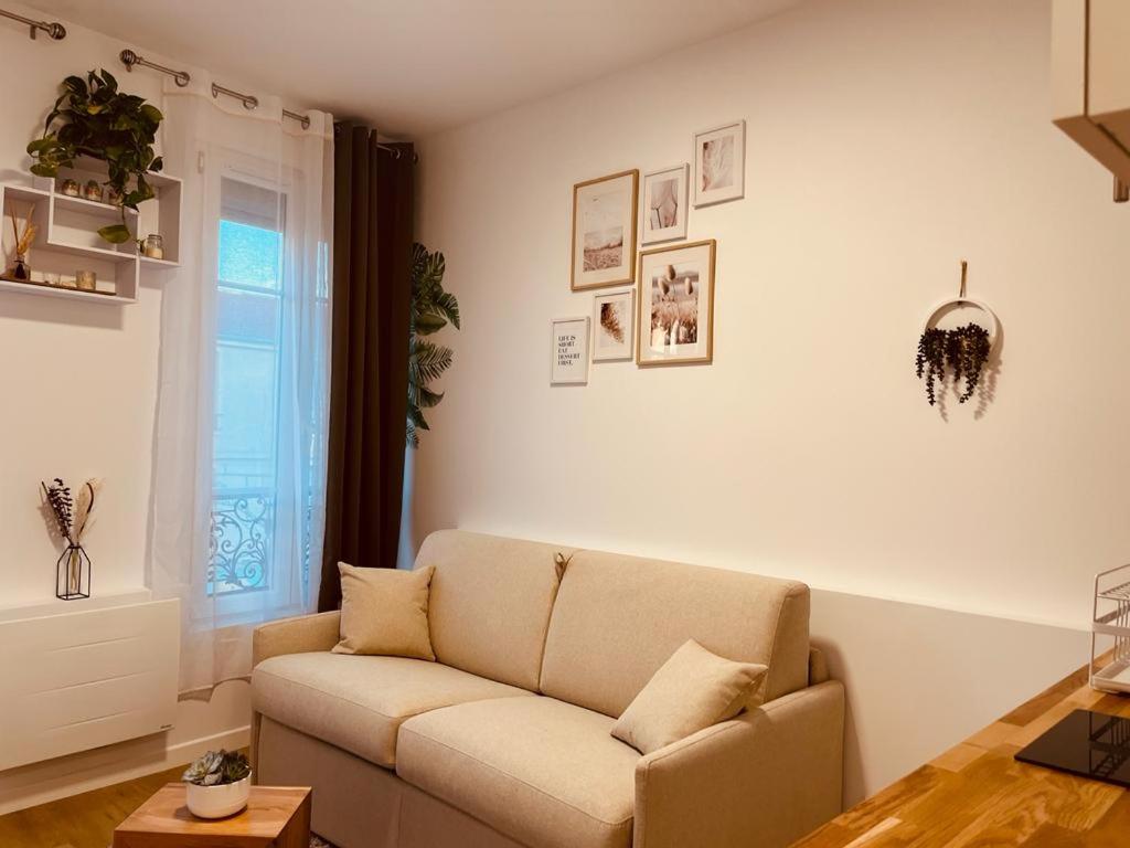 丁香镇Mignon petit studio 16m2的带沙发和窗户的客厅