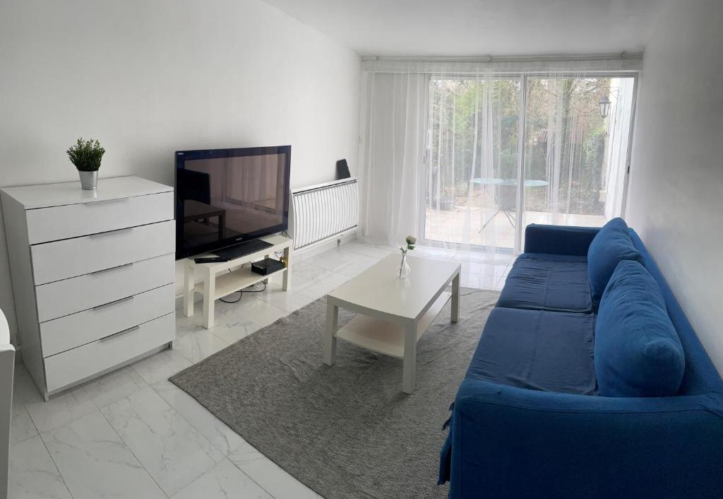 安东尼Maison indépendante 7 minutes RER B的客厅配有蓝色的沙发和电视