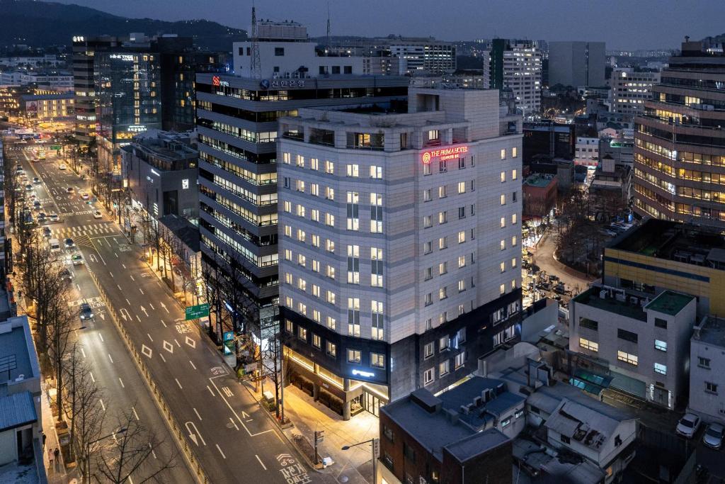首尔The Prima Hotel Jongno的夜晚在城市里高大的白色建筑