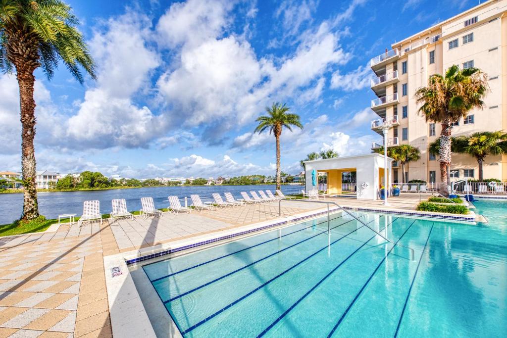 巴拿马城海滩Carillon Beach Resort Inn的棕榈树建筑前的游泳池