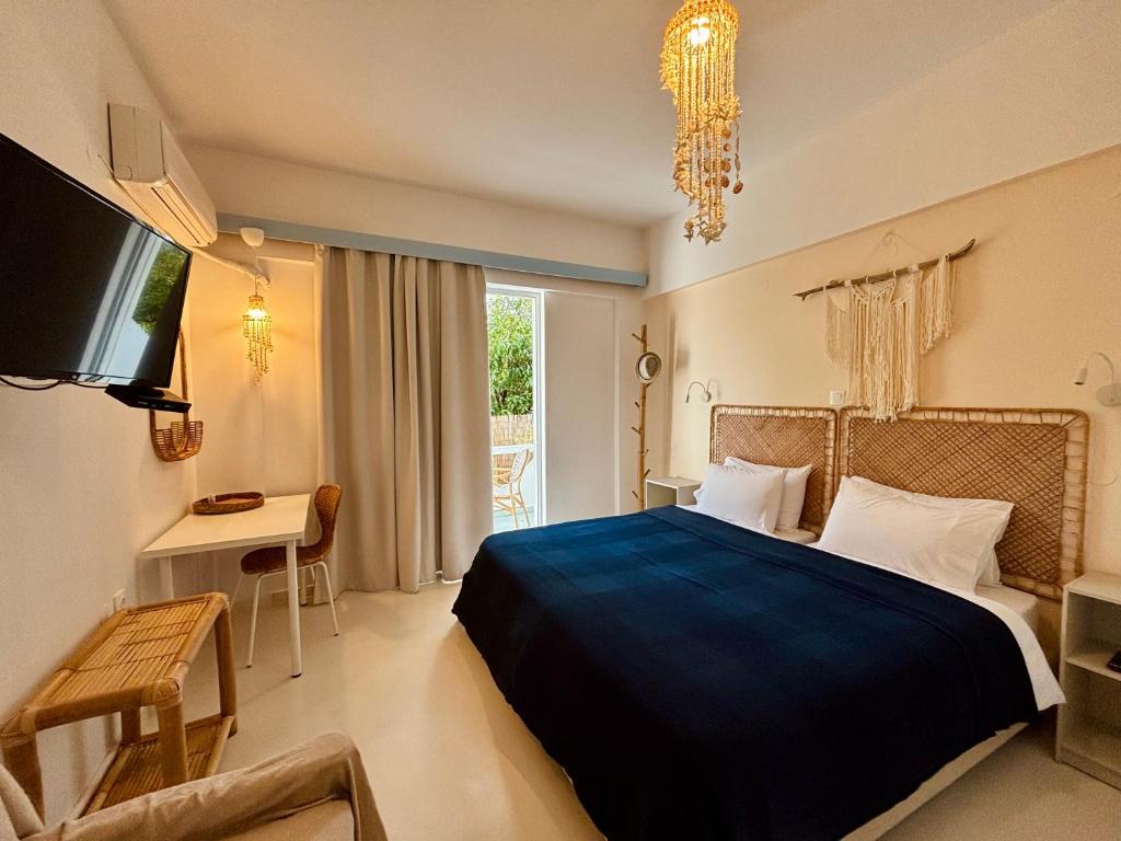 阿彻奇洛斯Afroditi Junior Suites的一间卧室配有一张床、一张书桌和一台电视