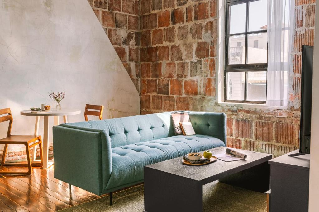 新奥尔良Sonder The Schaeffer的客厅设有蓝色的沙发和砖墙