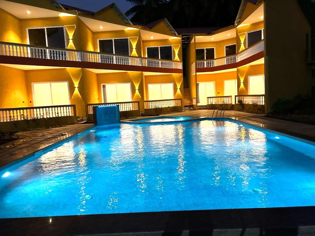 莫尔吉姆Eutopia Beach Resort - Boutique Resort with Pool by Rio Hotels India的大楼前的大型游泳池