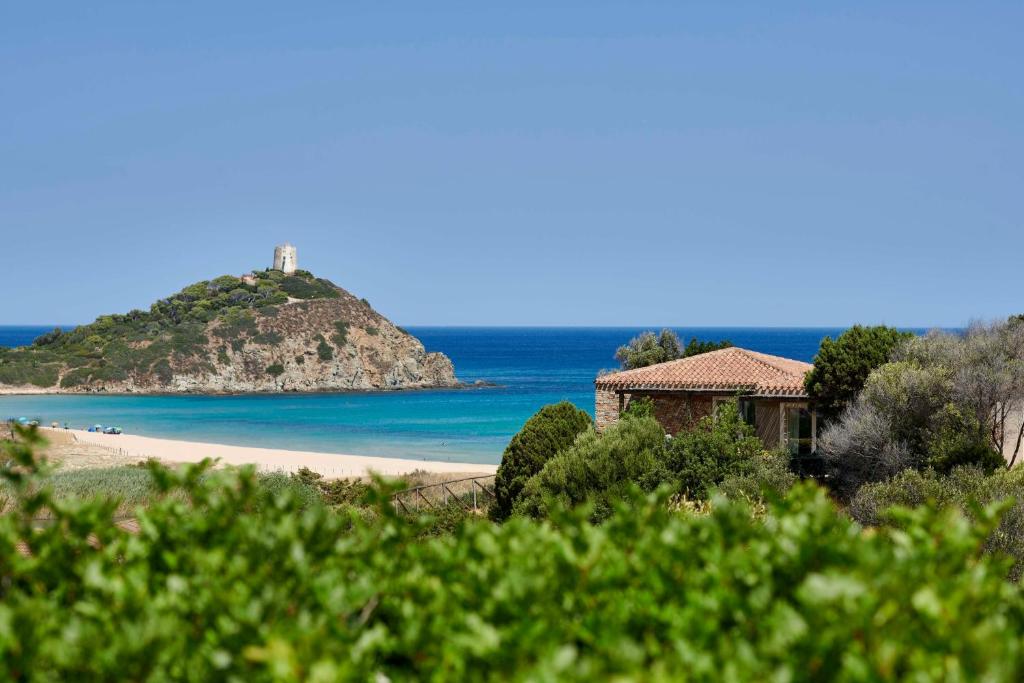 奇亚Baia Di Chia Resort Sardinia, Curio Collection By Hilton的拥有房子的海滩和大海