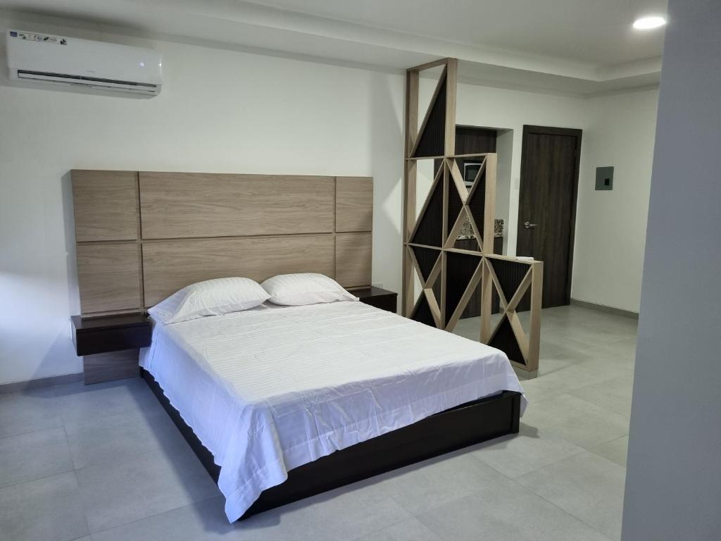 瓜亚基尔SUITES GARZOTA的一间卧室配有一张大床和木制床头板