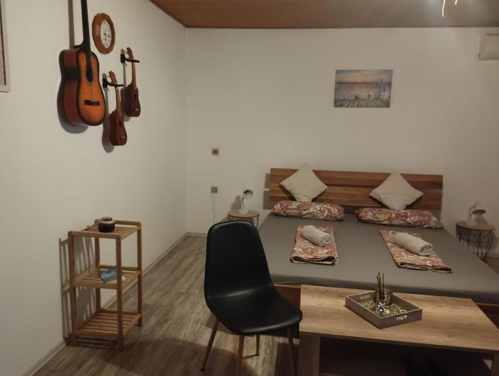 洛雷茨卡Apartment Summer Nest的配有一张床、一张桌子和吉他的房间