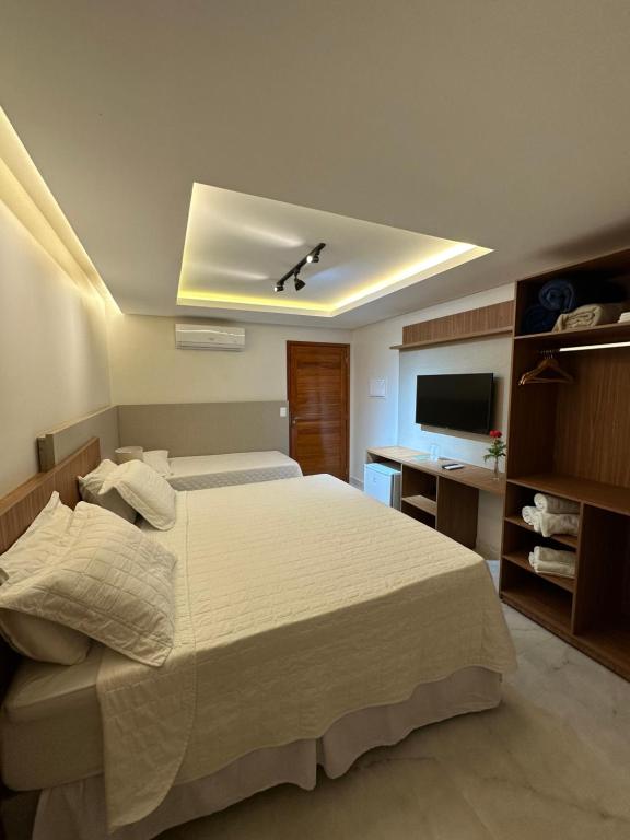 特里温福Pousada Baixa Verde的一间卧室配有一张大床和电视