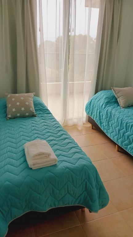 美国别墅城Condominio Monte Molinos - dpto en Nautico, 2 dormitorios y vista al lago的一张带绿色棉被的床