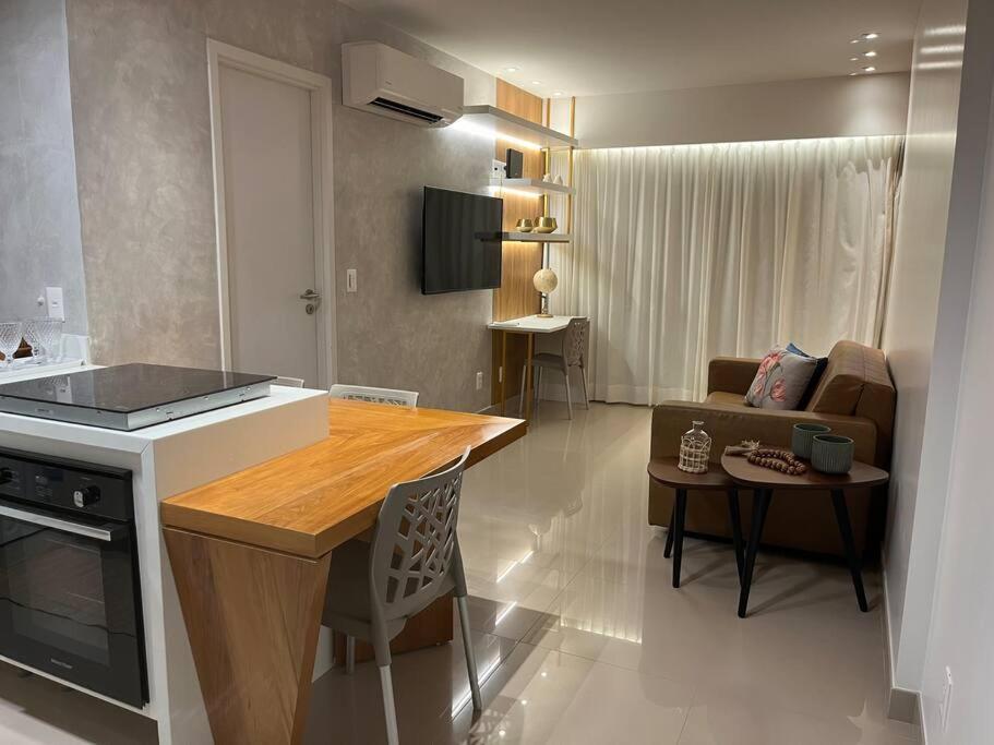 累西腓Flat em Boa Viagem的厨房以及带桌子和沙发的客厅。