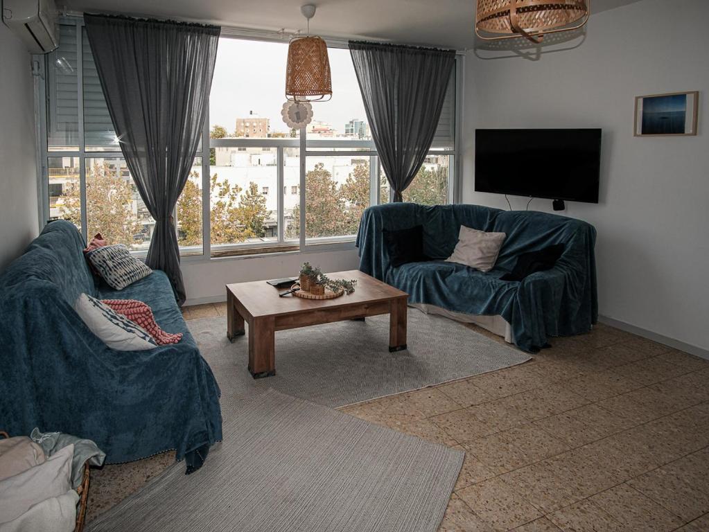 内坦亚Appartement cosy sur Netanya的客厅配有2张蓝色沙发和1张咖啡桌