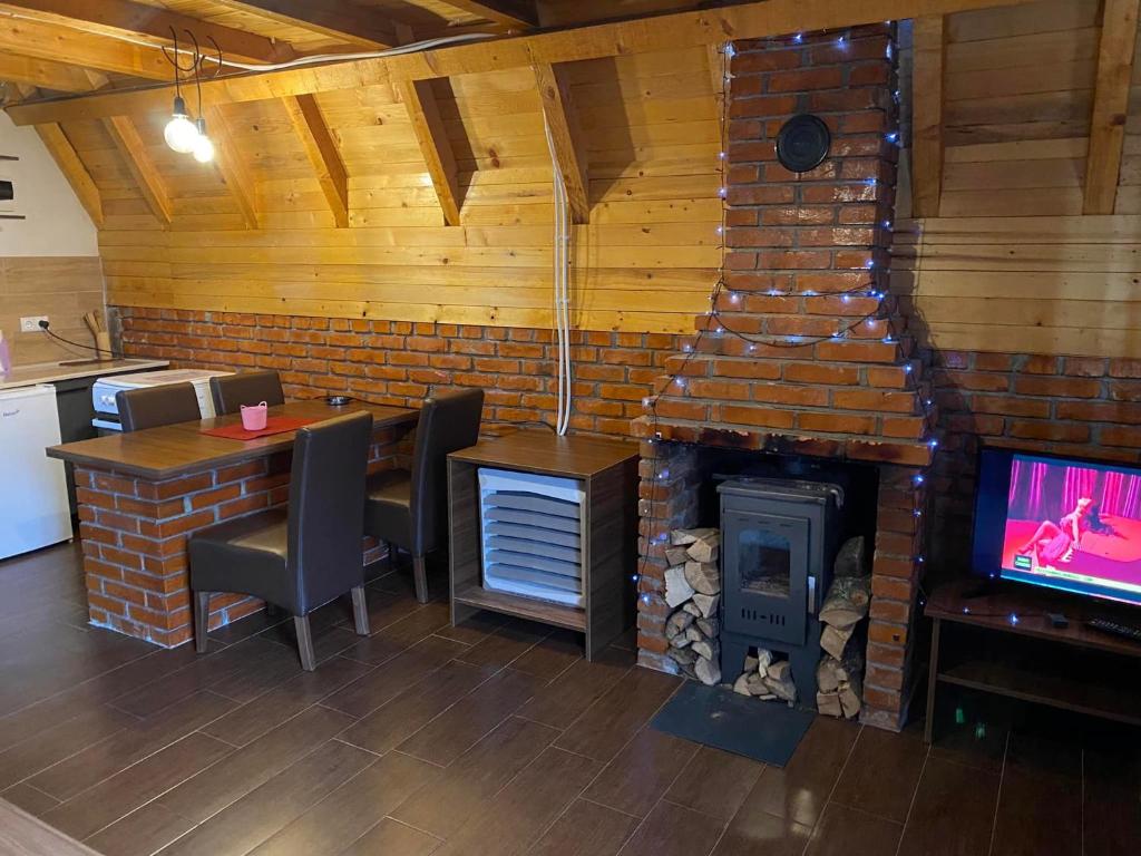 NovoberdoSTANET Forest Houses的客房设有壁炉、桌子和电视。