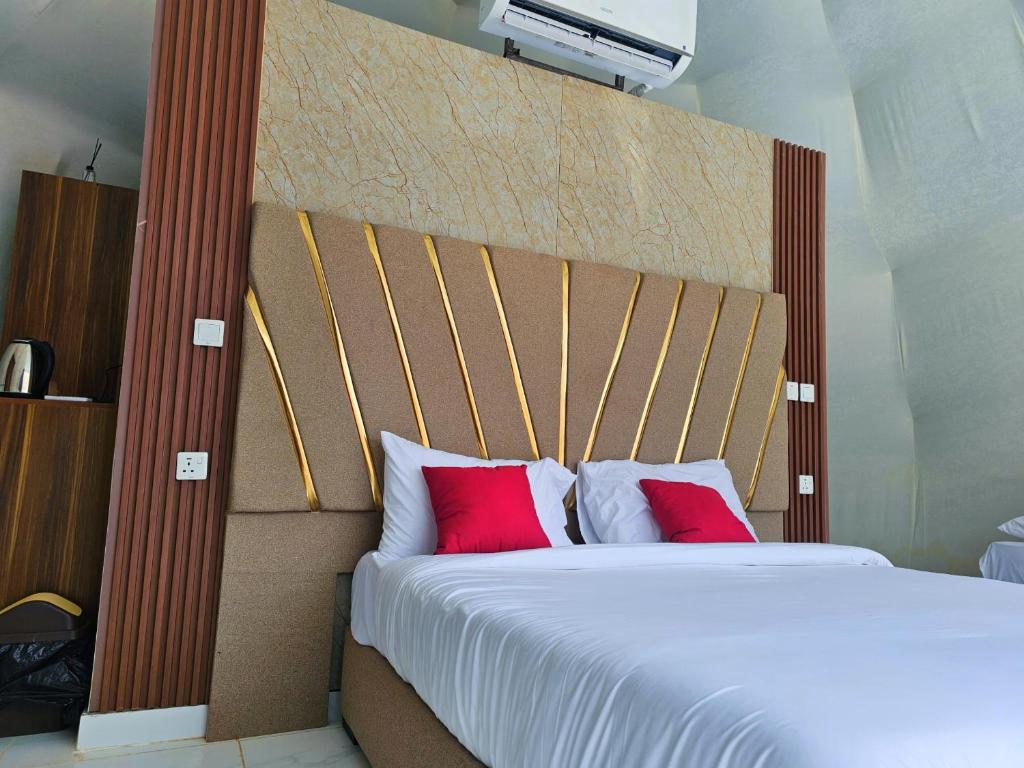 DisahEuropean luxury camp的一间卧室配有一张大床和两个红色枕头