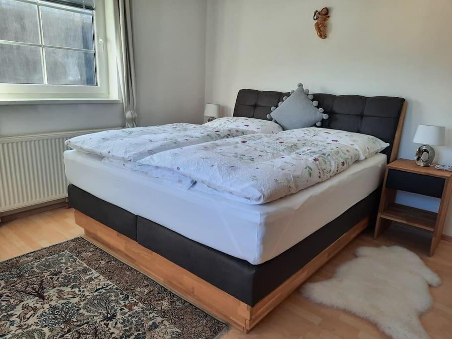 格拉茨Wohnen in Graz Mariatrost的卧室内的一张床位,配有黑色和白色床垫