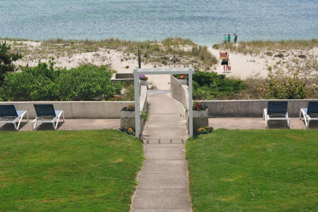 南雅茅斯冲浪和沙滩汽车旅馆的通往带椅子的海滩和大海的路径