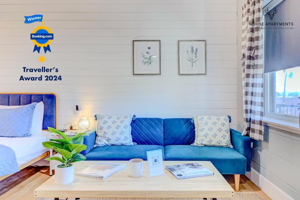 孟菲斯The Moose #8 - Modern Luxe Loft with King Bed & Free Parking & Wifi的客厅配有一张蓝色的沙发,配有一张桌子